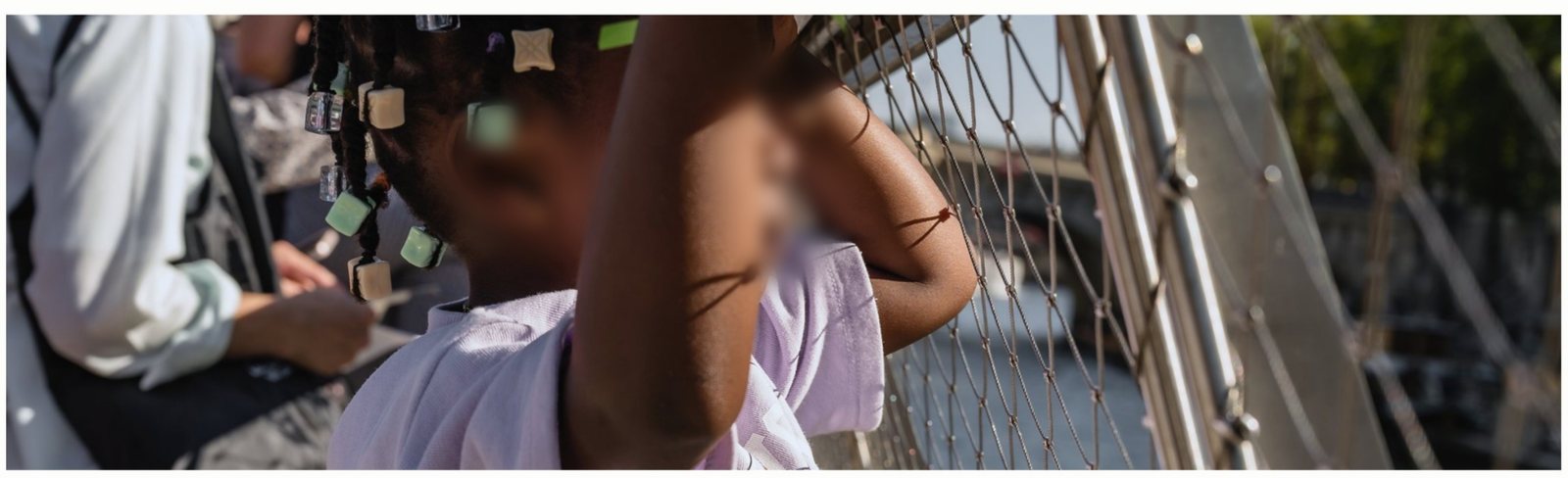 Un enfant accoudé au bastingage regarde Paris défiler pendant la croisière sur la Seine