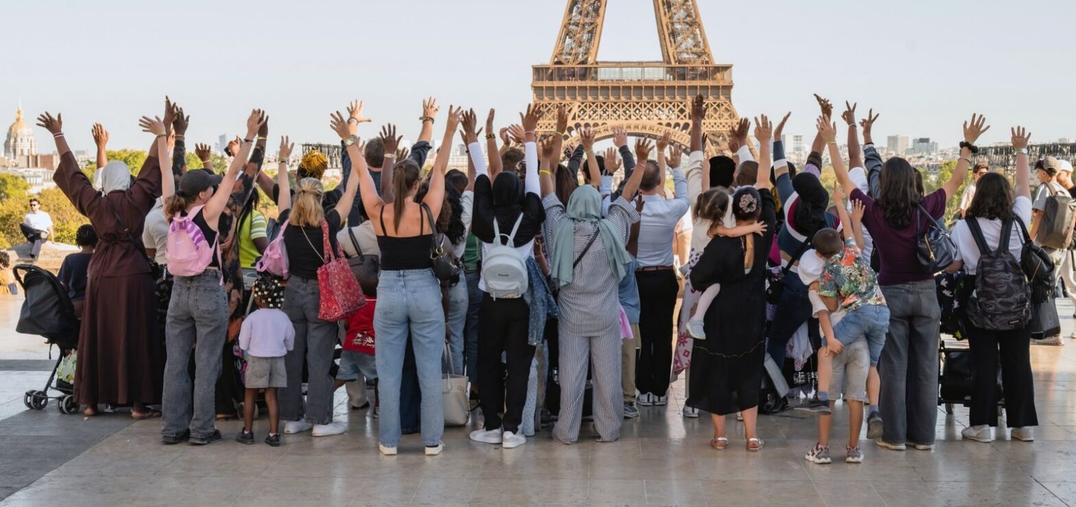 Les familles de la Maison Pauline Kergomard et les collaborateurs de Goron, bras levés face à la tour Eiffel au Trocadéro