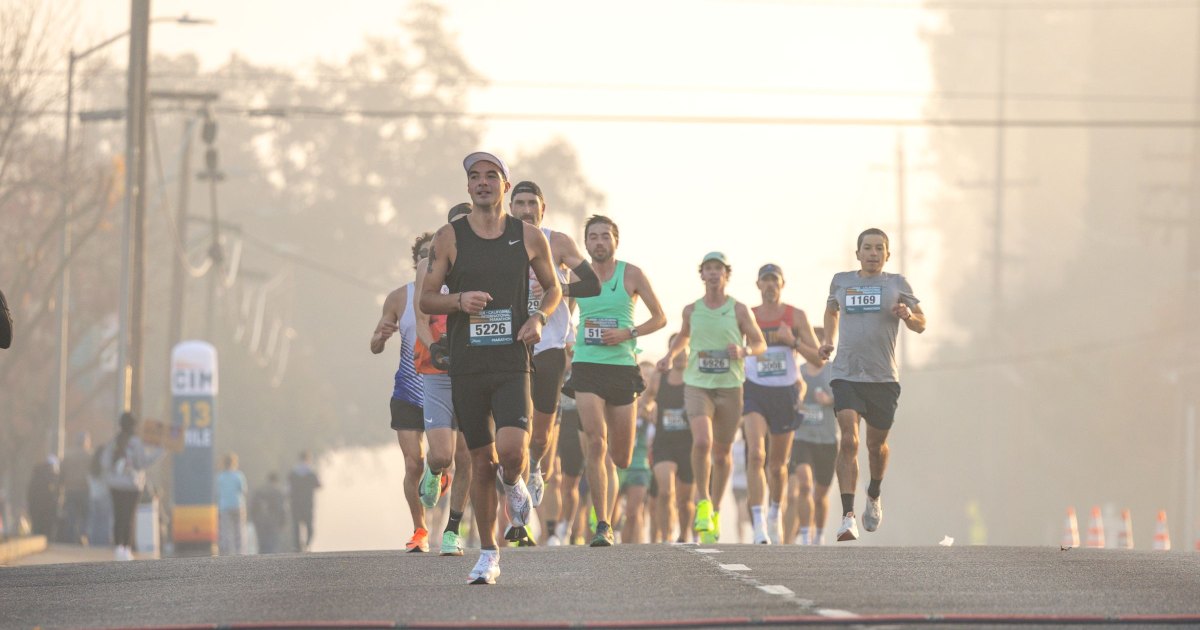 Coureurs groupés dans une rue au petit matin lors d'un marathon